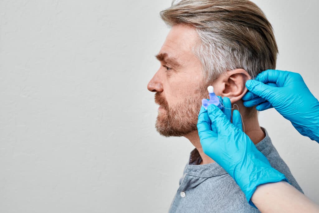 Man getting custom ear molds from his local hearing clinic